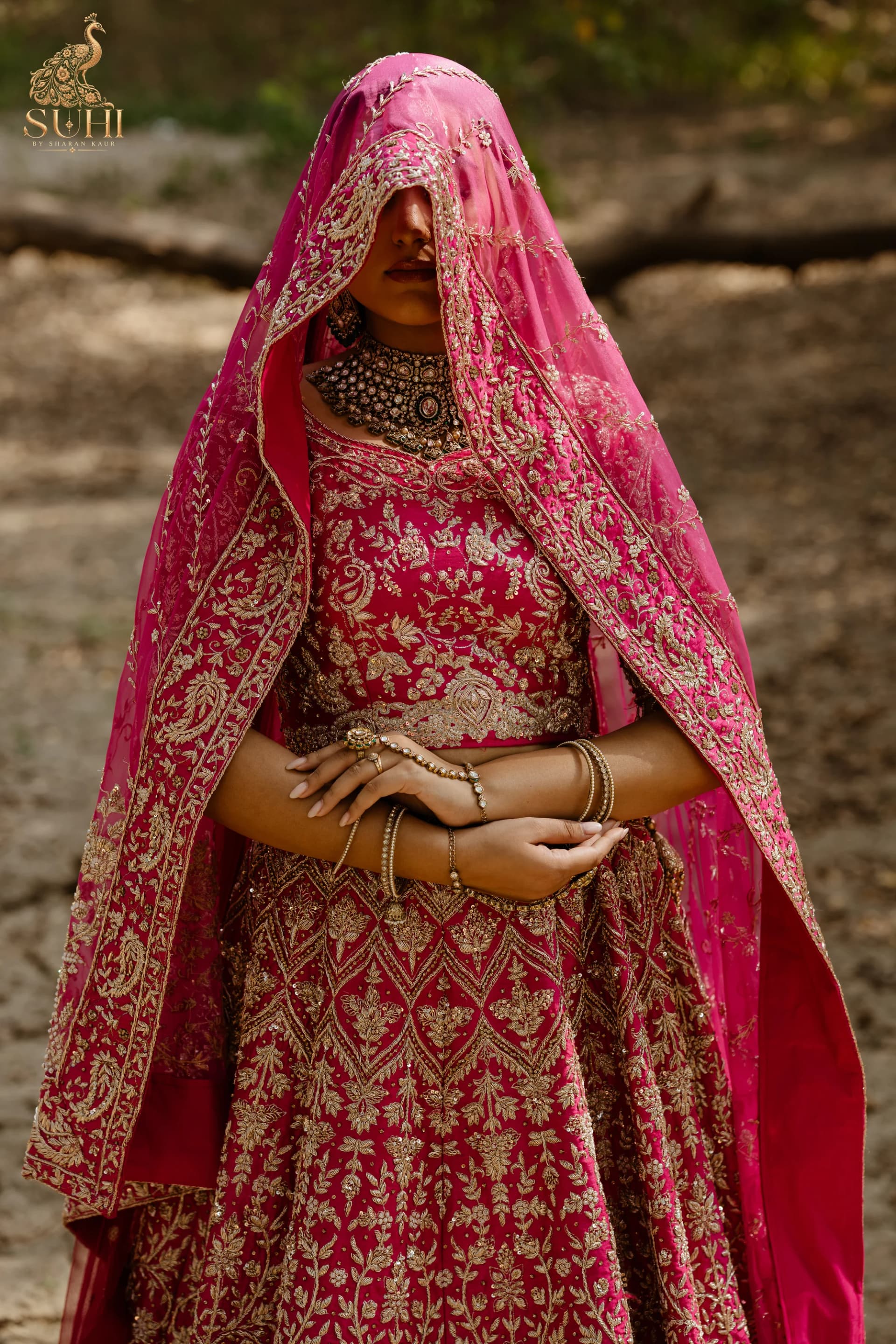 Bride veiled in the RAANI GUL dupatta, hands folded over the embroidered lehenga